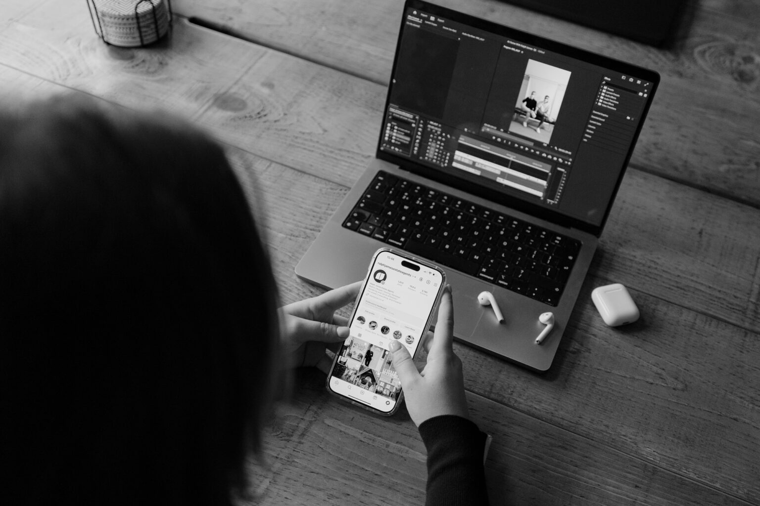 A black and white view of a laptop and phone showing the Ralph James social feed